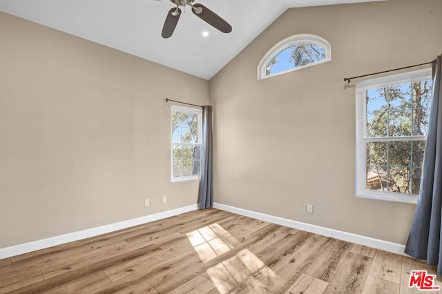 spare room featuring high vaulted ceiling, ceiling fan, and light wood-type flooring