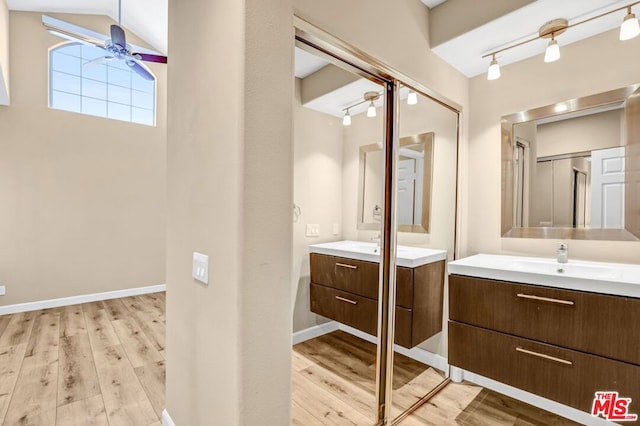 bathroom with vanity, vaulted ceiling, hardwood / wood-style floors, and ceiling fan