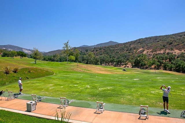 view of home's community with a mountain view and a lawn