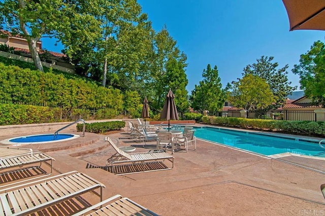 view of swimming pool with a hot tub and a patio area