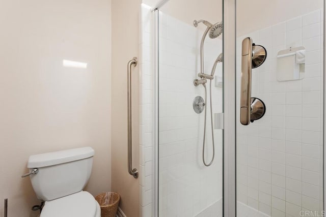 bathroom with a shower with door and toilet