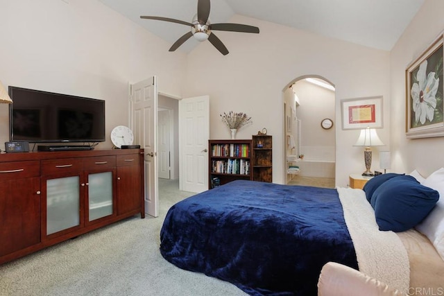 bedroom featuring ensuite bath, vaulted ceiling, light colored carpet, and ceiling fan