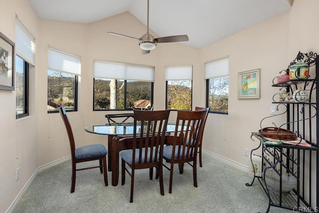 carpeted dining space featuring ceiling fan and lofted ceiling