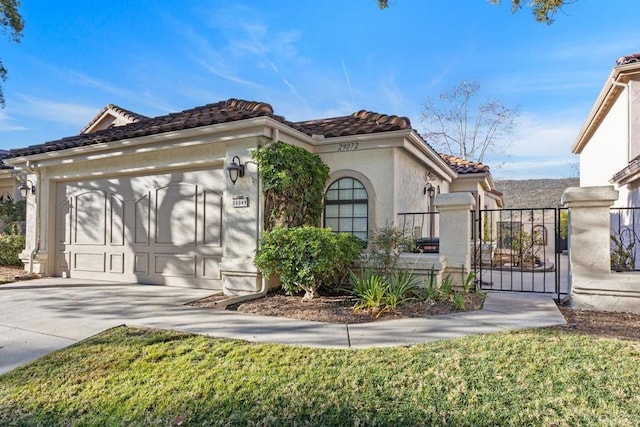 mediterranean / spanish house with a garage and a front yard