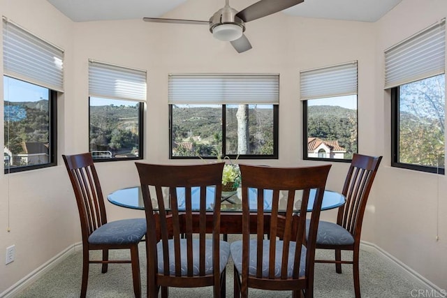 dining room with vaulted ceiling, carpet, a mountain view, and ceiling fan