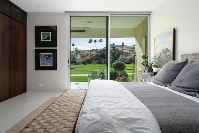 bedroom featuring expansive windows, a mountain view, and access to outside