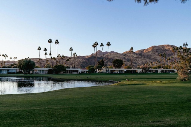 view of property's community featuring a yard and a water and mountain view