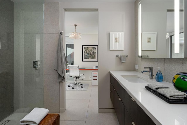 bathroom featuring tiled shower, vanity, tile patterned flooring, and decorative backsplash