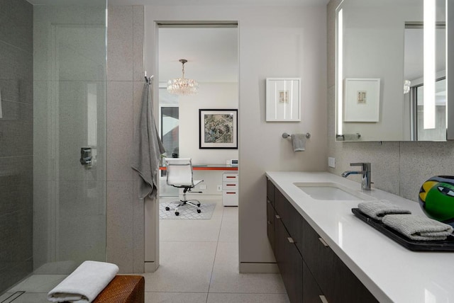 bathroom with vanity, decorative backsplash, tile patterned floors, and a tile shower