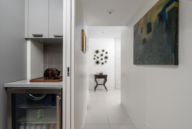 hallway with light tile patterned flooring and beverage cooler