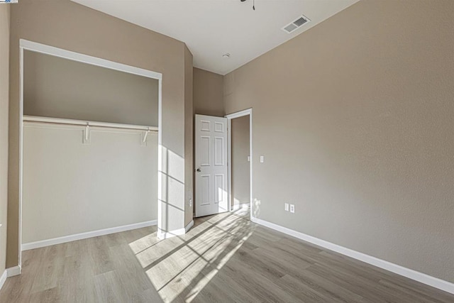 unfurnished bedroom with light hardwood / wood-style flooring and a closet