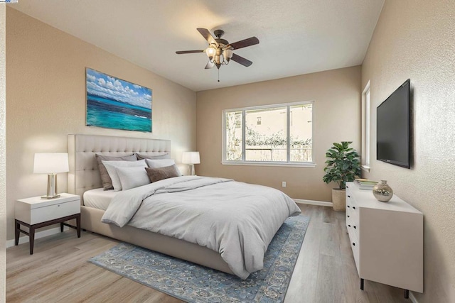 bedroom with ceiling fan and light hardwood / wood-style flooring