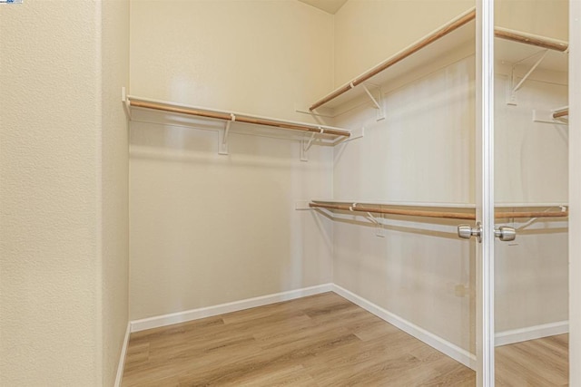 walk in closet with hardwood / wood-style flooring