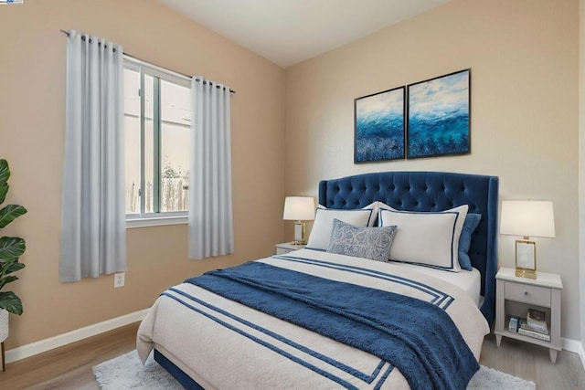 bedroom with hardwood / wood-style floors and multiple windows