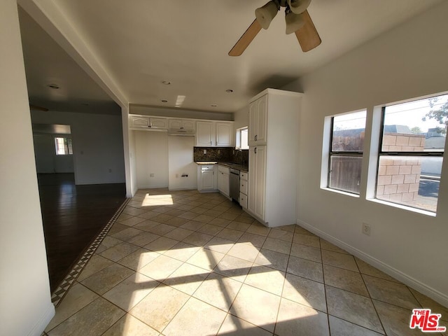 kitchen with ceiling fan, dishwasher, white cabinetry, light tile patterned flooring, and decorative backsplash