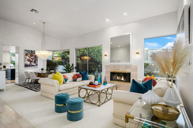 living room featuring high vaulted ceiling, an inviting chandelier, and a fireplace