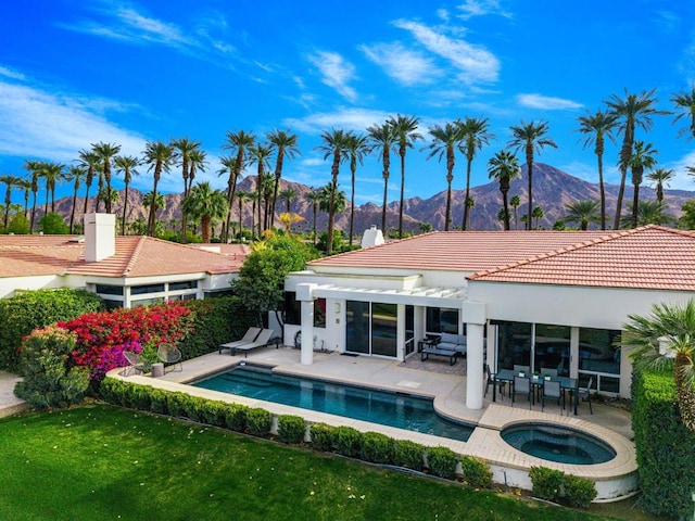 view of pool with an in ground hot tub, a mountain view, and a patio area