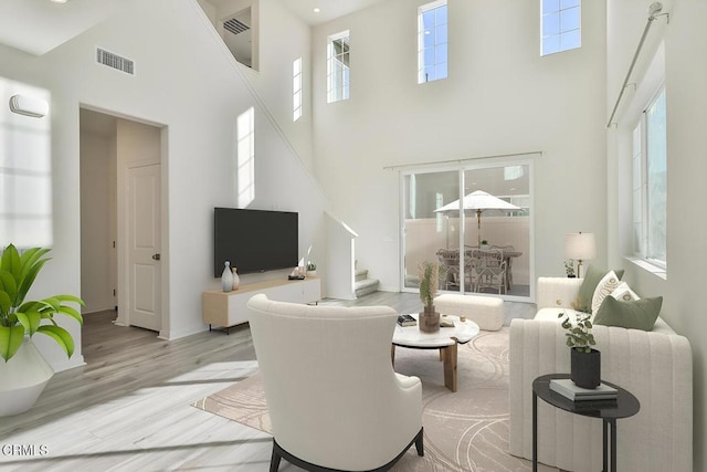 living room with light hardwood / wood-style floors and a high ceiling