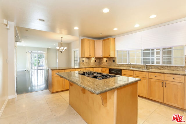 kitchen with light stone counters, a breakfast bar, sink, and a kitchen island