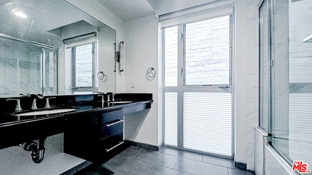 bathroom featuring vanity, combined bath / shower with glass door, and tile patterned floors