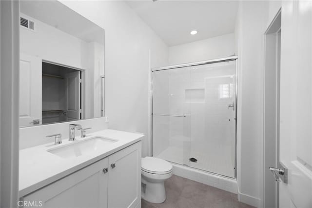 bathroom with vanity, tile patterned floors, a shower with door, and toilet