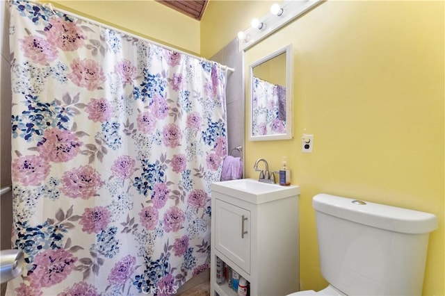 bathroom with vanity, curtained shower, and toilet
