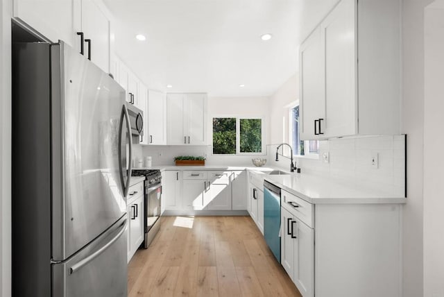 kitchen featuring white cabinetry, stainless steel appliances, sink, and tasteful backsplash