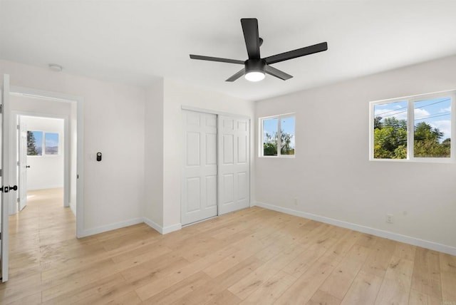 unfurnished bedroom featuring ceiling fan, a closet, and light hardwood / wood-style flooring