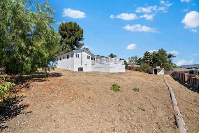 view of side of property with a sunroom and a shed