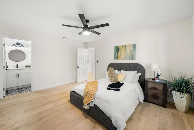 bedroom with connected bathroom, light hardwood / wood-style flooring, and ceiling fan