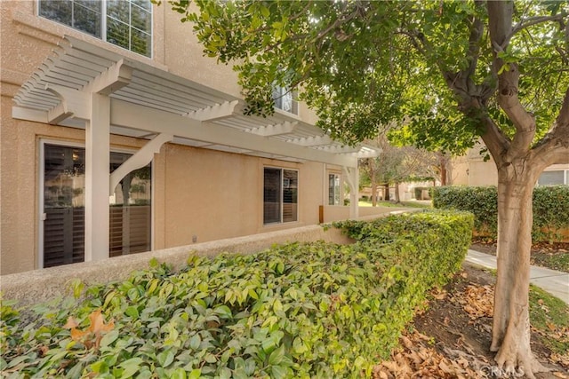 view of property exterior with a pergola