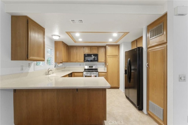 kitchen featuring sink, a tray ceiling, black appliances, and kitchen peninsula