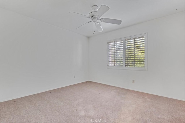 spare room with ceiling fan and light colored carpet