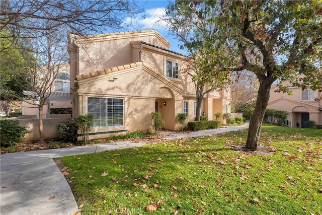 mediterranean / spanish house with a front lawn