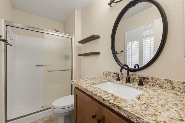 bathroom with vanity, a shower with shower door, tile patterned floors, and toilet