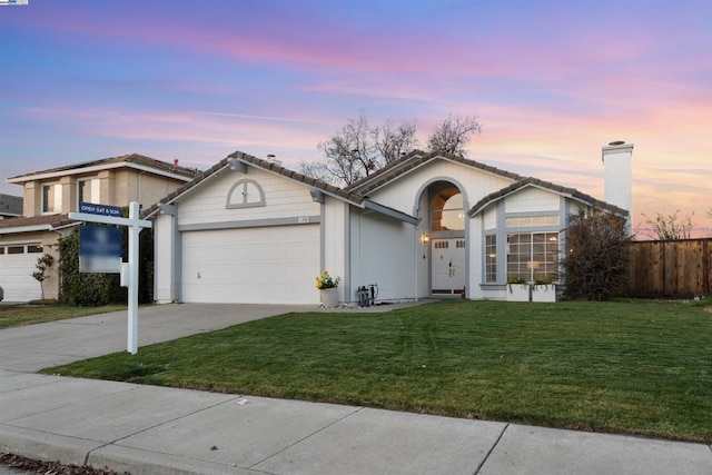 view of front of property featuring a garage and a lawn