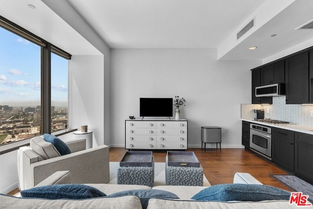 living room with plenty of natural light and dark hardwood / wood-style flooring