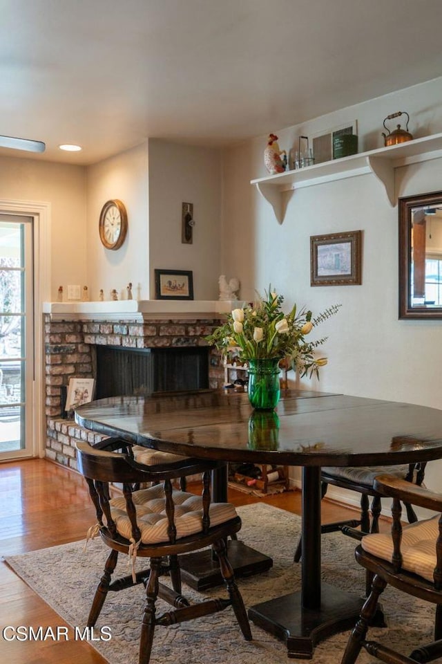 dining room featuring hardwood / wood-style flooring and a fireplace