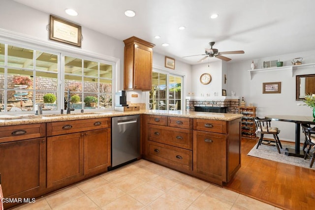 kitchen featuring sink, light tile patterned floors, dishwasher, kitchen peninsula, and ceiling fan