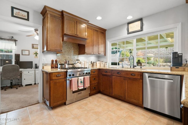 kitchen featuring sink, appliances with stainless steel finishes, light colored carpet, light stone countertops, and decorative backsplash