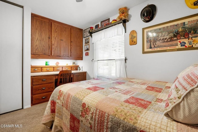 bedroom with built in desk and carpet flooring