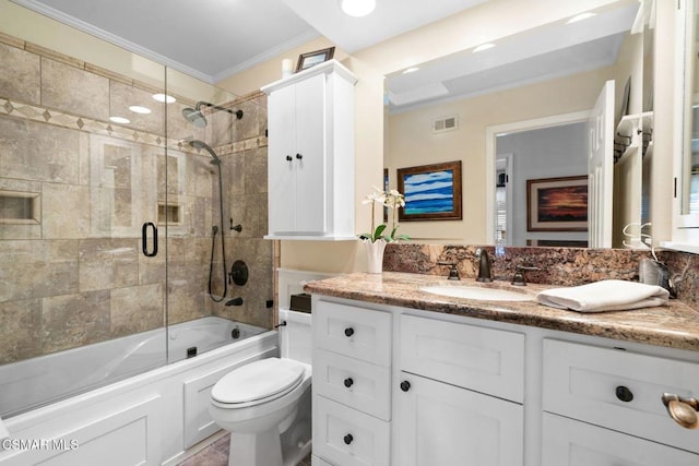 full bathroom featuring vanity, bath / shower combo with glass door, ornamental molding, and toilet