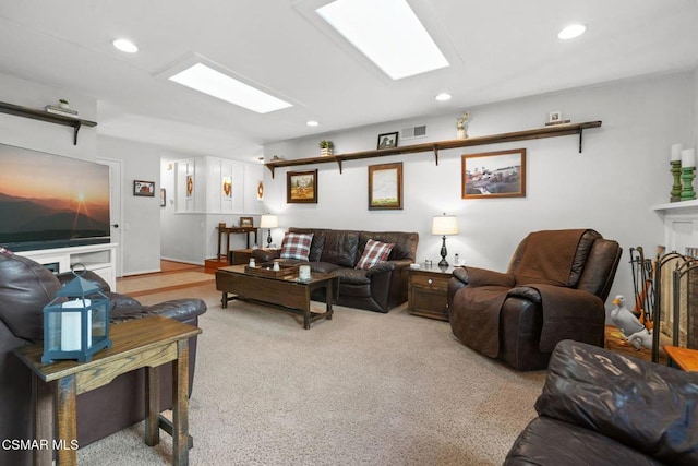 carpeted living room featuring a skylight