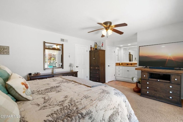 carpeted bedroom featuring ceiling fan and ensuite bath