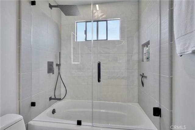 bathroom featuring shower / bath combination with glass door and toilet