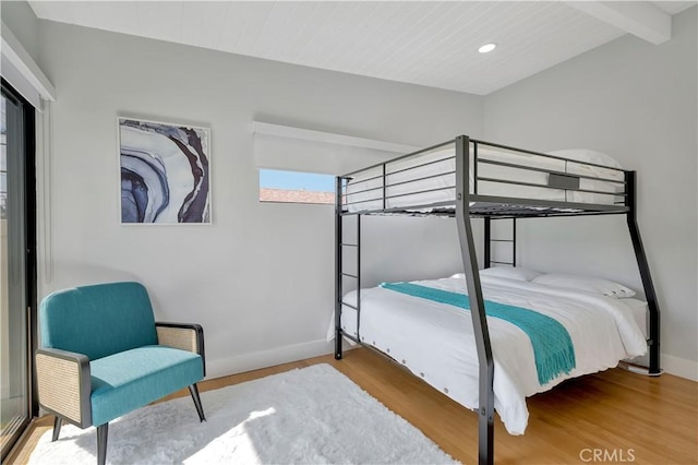 bedroom featuring beamed ceiling and hardwood / wood-style floors