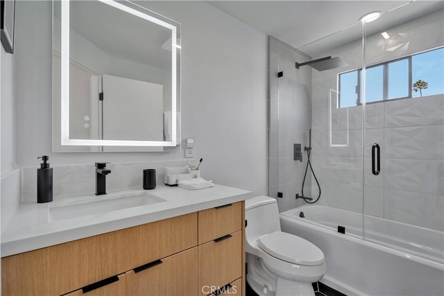 full bathroom with vanity, shower / bath combination with glass door, and toilet