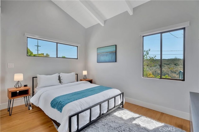 bedroom with beamed ceiling, wood-type flooring, high vaulted ceiling, and multiple windows