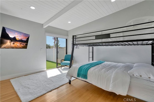 bedroom featuring beamed ceiling, wood ceiling, wood-type flooring, and access to outside