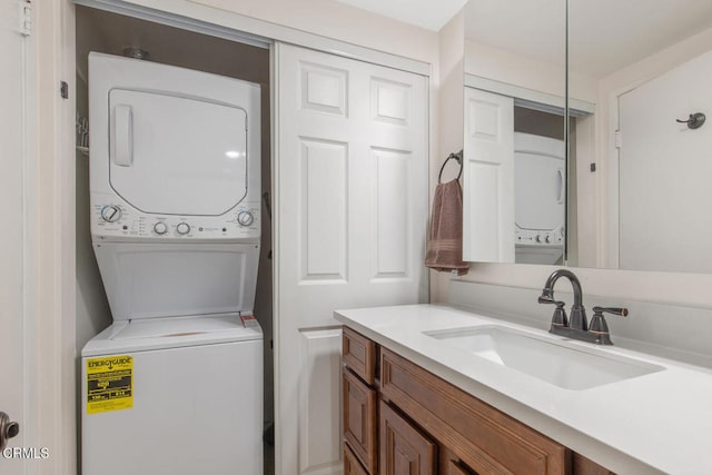 washroom featuring stacked washer and dryer and sink